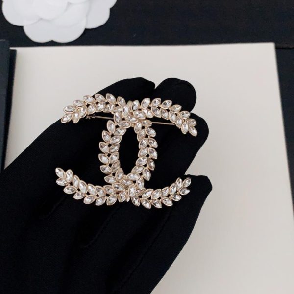 replica,repliche,fake,1:1,earrings,bracelet,ring,jewelry Spilla Chanel cc con occhio di cavallino