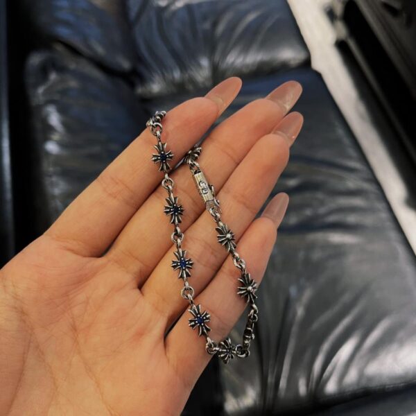 Bracciale con croce di diamanti blu e cuori cromati